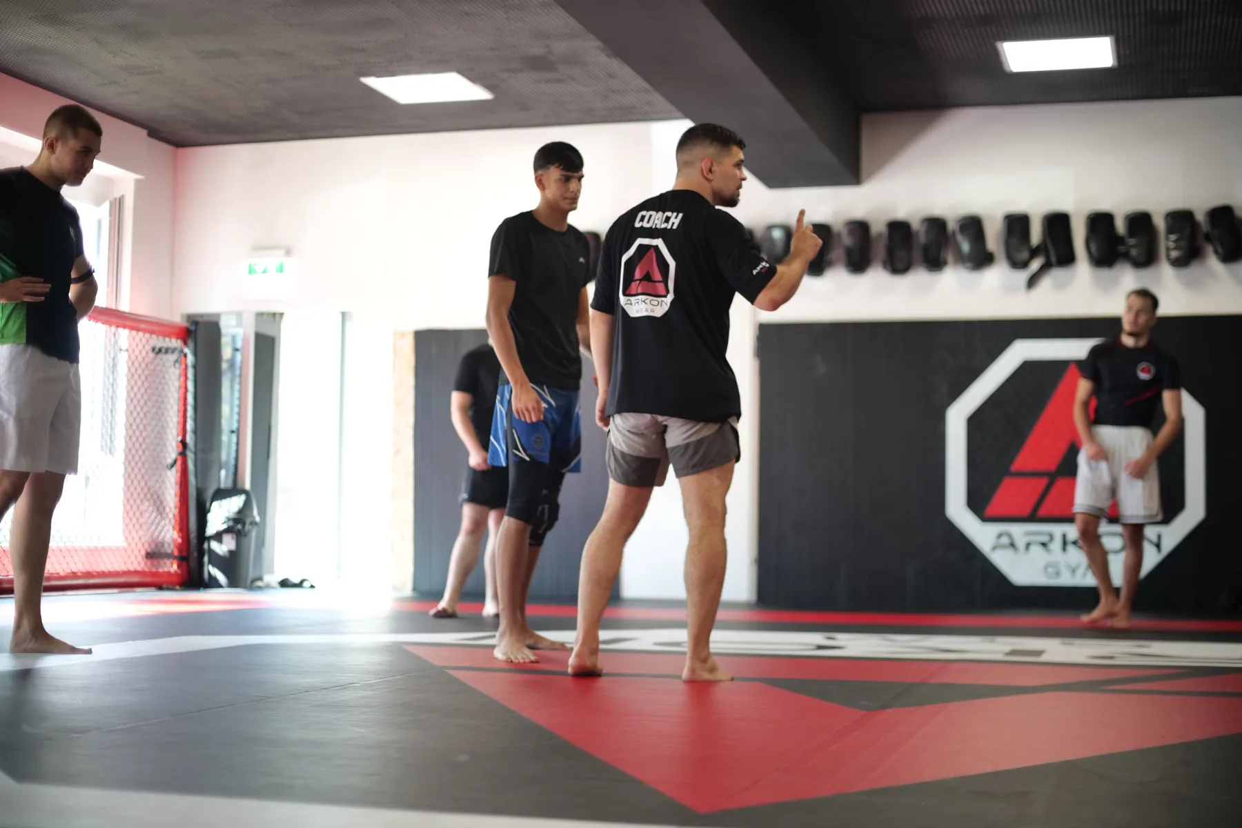 Coach erklärt eine MMA-Technik auf der Matte